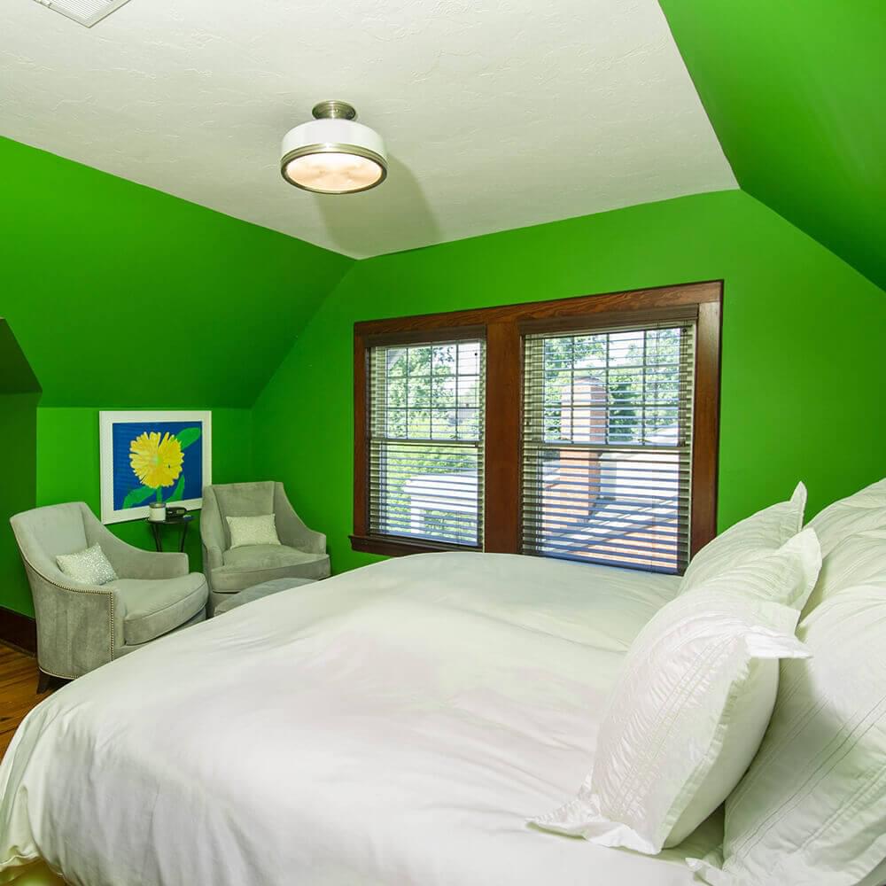 Green bedroom with ornate bed covers