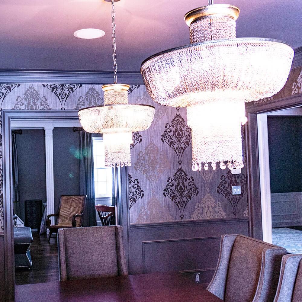 Dining room with two chandeliers and dark wallpaper